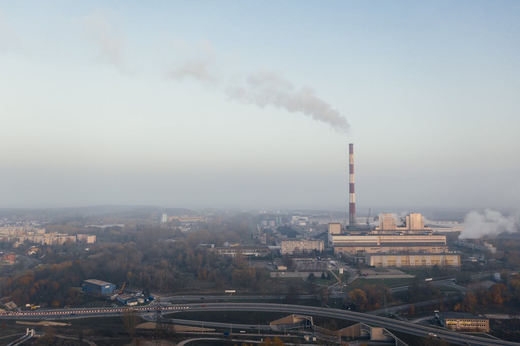 Global South Climate Change Impacts plant emitting smoke, highlighting urban air pollution and industrial impact.
