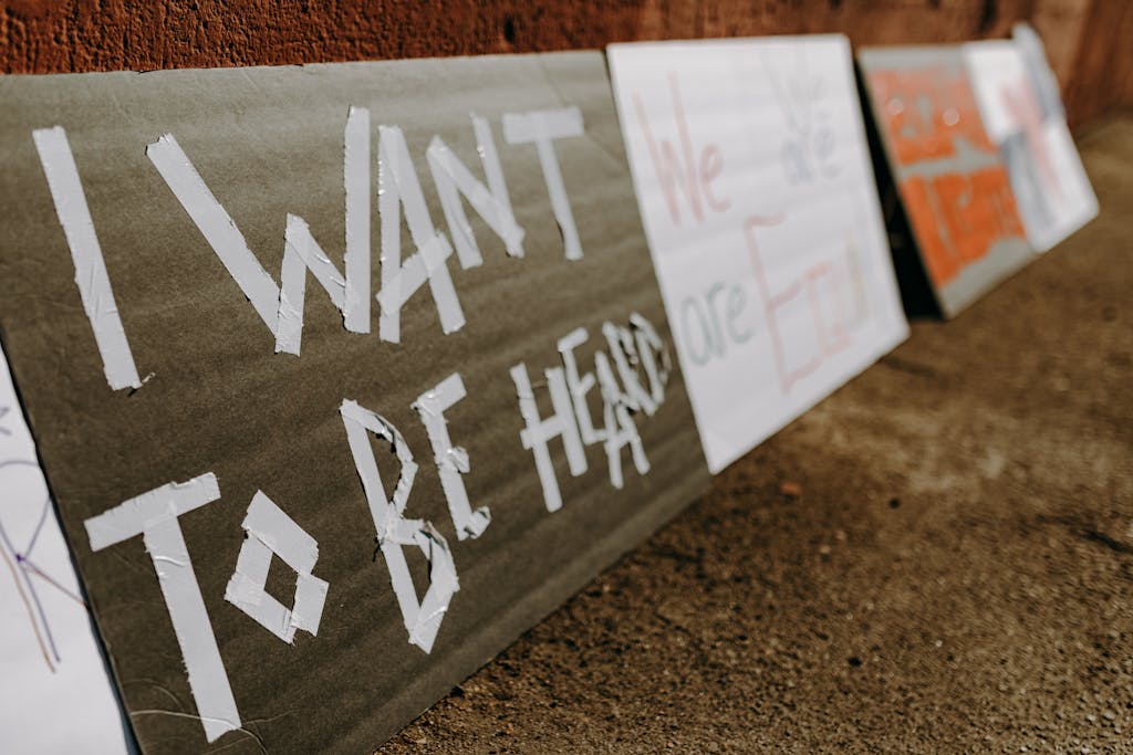 Civil Society Voices signs calling for equality and justice placed on the ground.