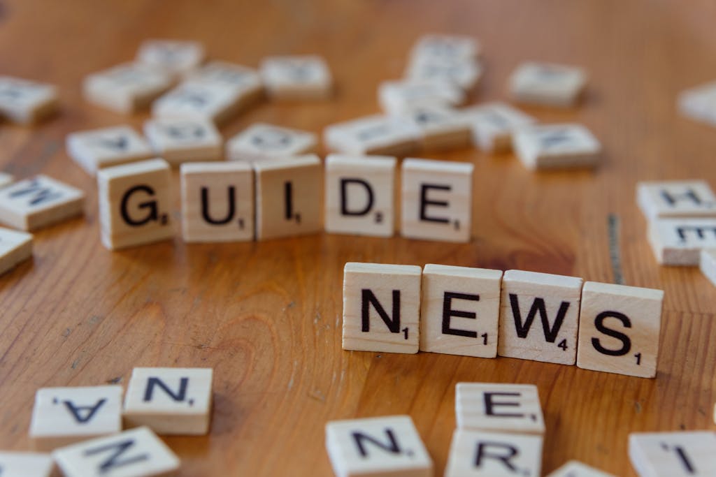 United Kingdom Press Release: A Complete Guide to Writing, Distribution, and Media Impact 2026 Close-up of Scrabble tiles spelling 'Guide' and 'News' on a wooden surface.