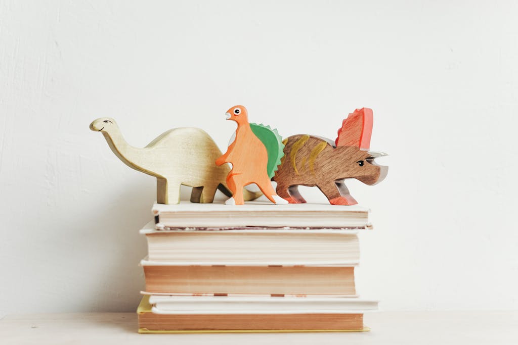 Story Protocol IP Tokenomics dinosaurs on top of a stack of hardcover books on a light background.