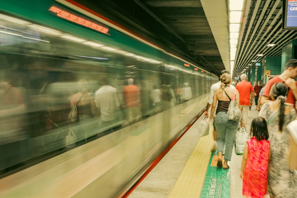 Get Fast Release News on IPS Commuters wait as a subway train passes by, capturing the hustle of urban travel.