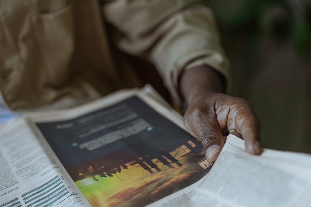 China Daily Web News Detailed close-up of a person holding and reading a newspaper indoors.