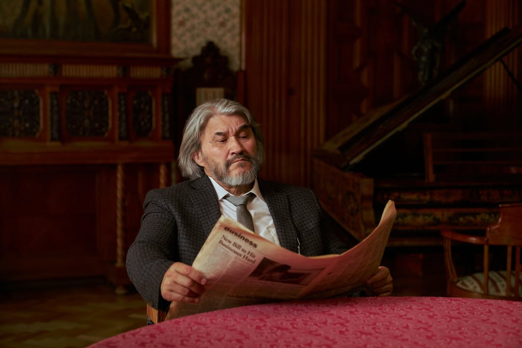 China Daily Web News Senior man in a suit reading a newspaper in a luxurious, vintage styled room.