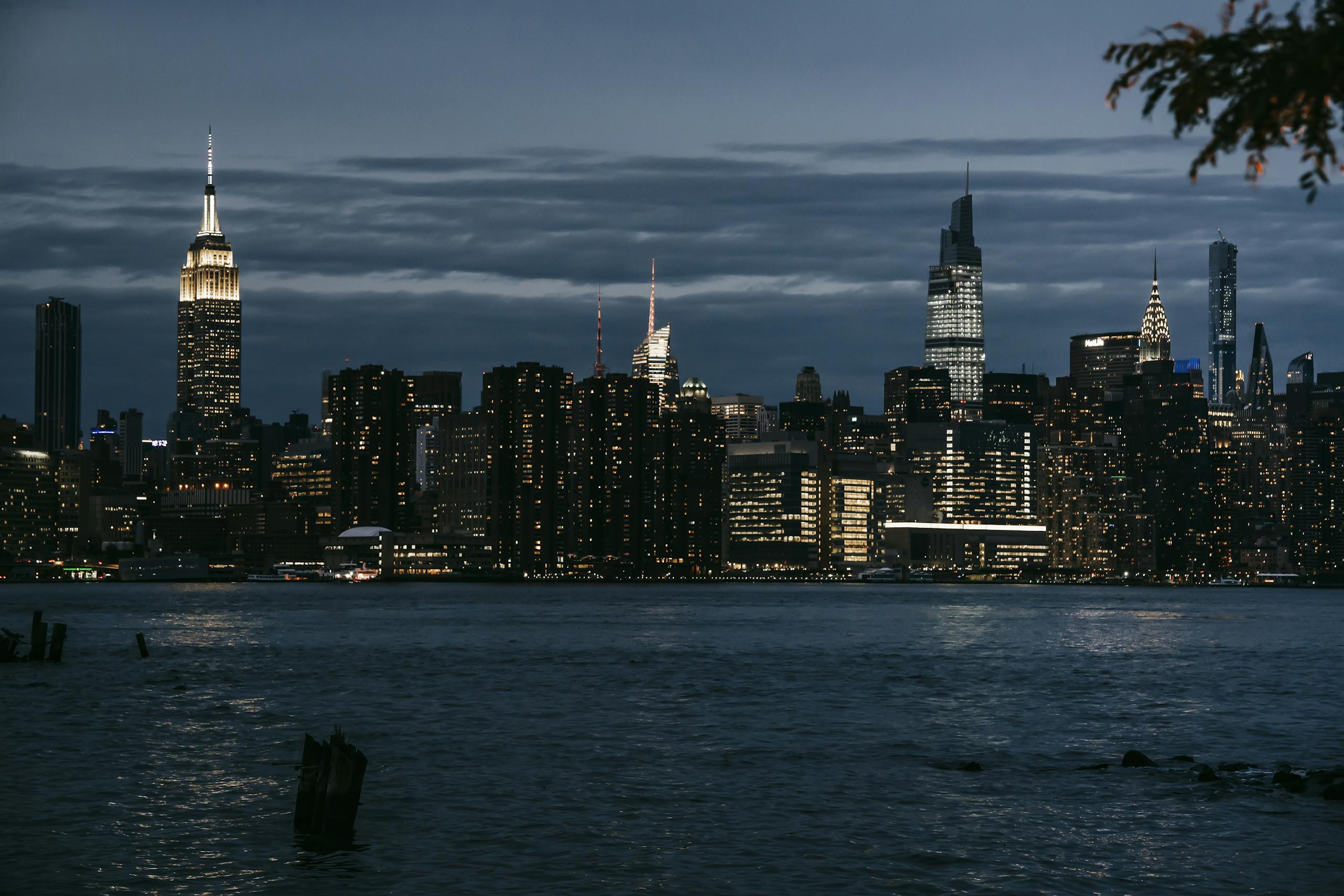 Tri Town News Sidney NY Obituaries illuminated towers located in central district on coast of rippling river in New York at night