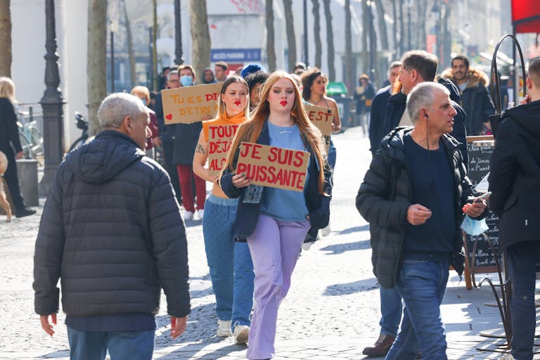 Civil Society Voices a city street holding signs in French, advocating for empowerment.