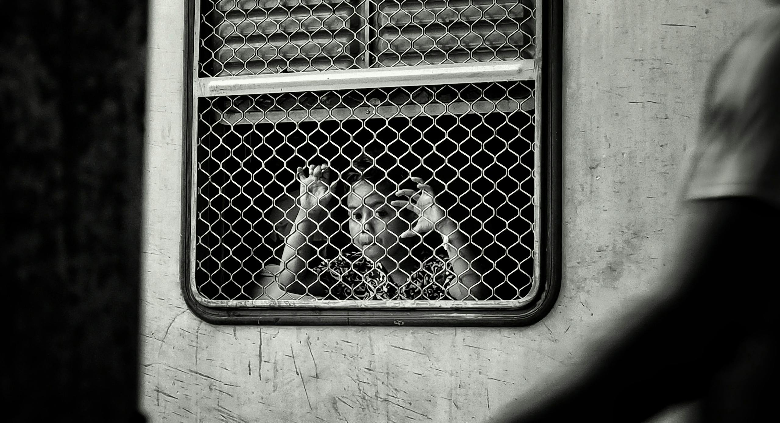 Chinese Train Breaks World Record, Hits 700 km/h in Just 2 Seconds A child looks through a mesh-covered train window, evoking curiosity and reflection.