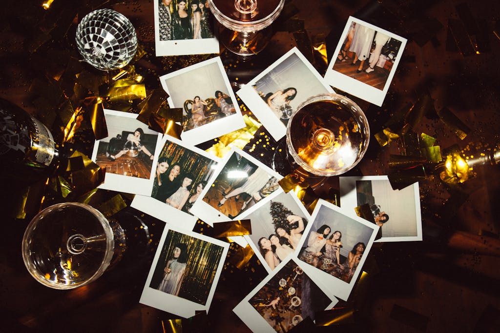 Sodiceram A collection of polaroid photos and glasses on a festive table, capturing party memories.