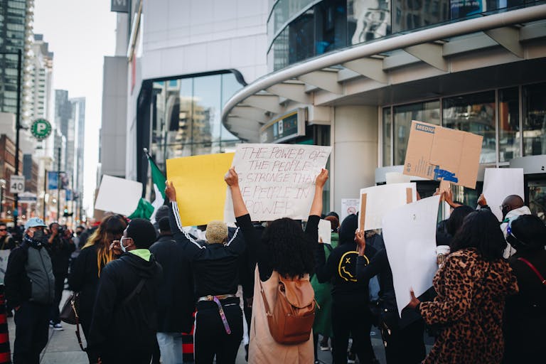 Ontario Probate News A diverse group of protesters gathers in Toronto holding signs advocating for social change.