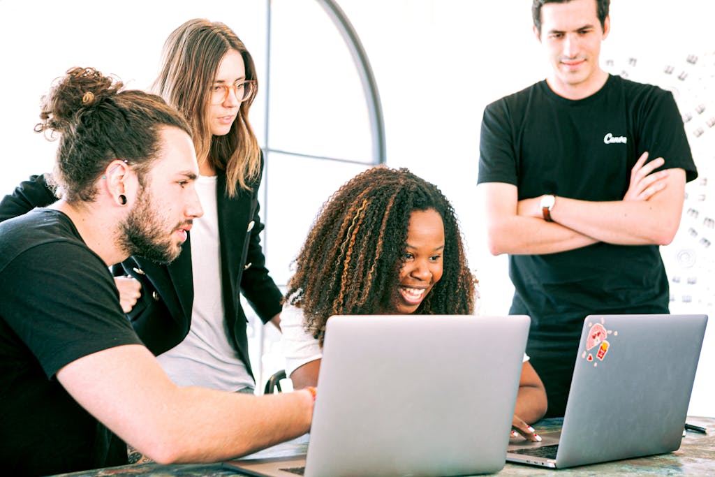 TabooTube A diverse group of young professionals collaborating enthusiastically in a bright, modern workspace.