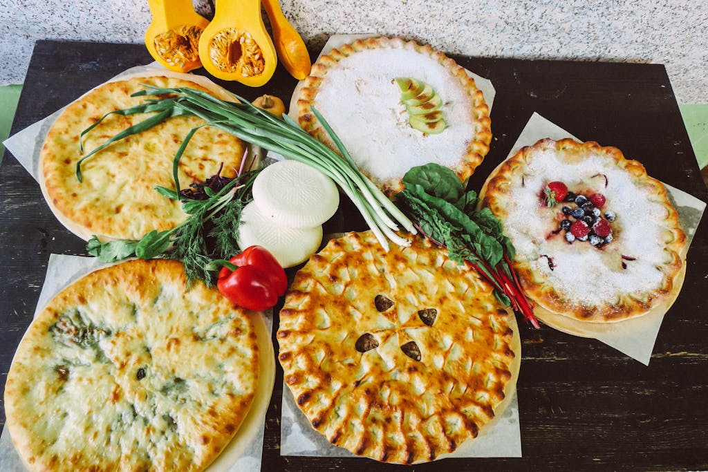 EO PIS A high-angle view of various pies with fresh vegetables, showcasing a mix of savory and sweet flavors.