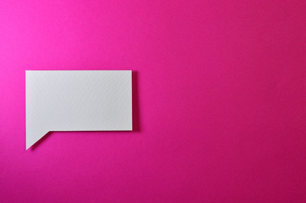 Cartetach A minimalistic white paper speech bubble on a vibrant pink background, perfect for design projects.