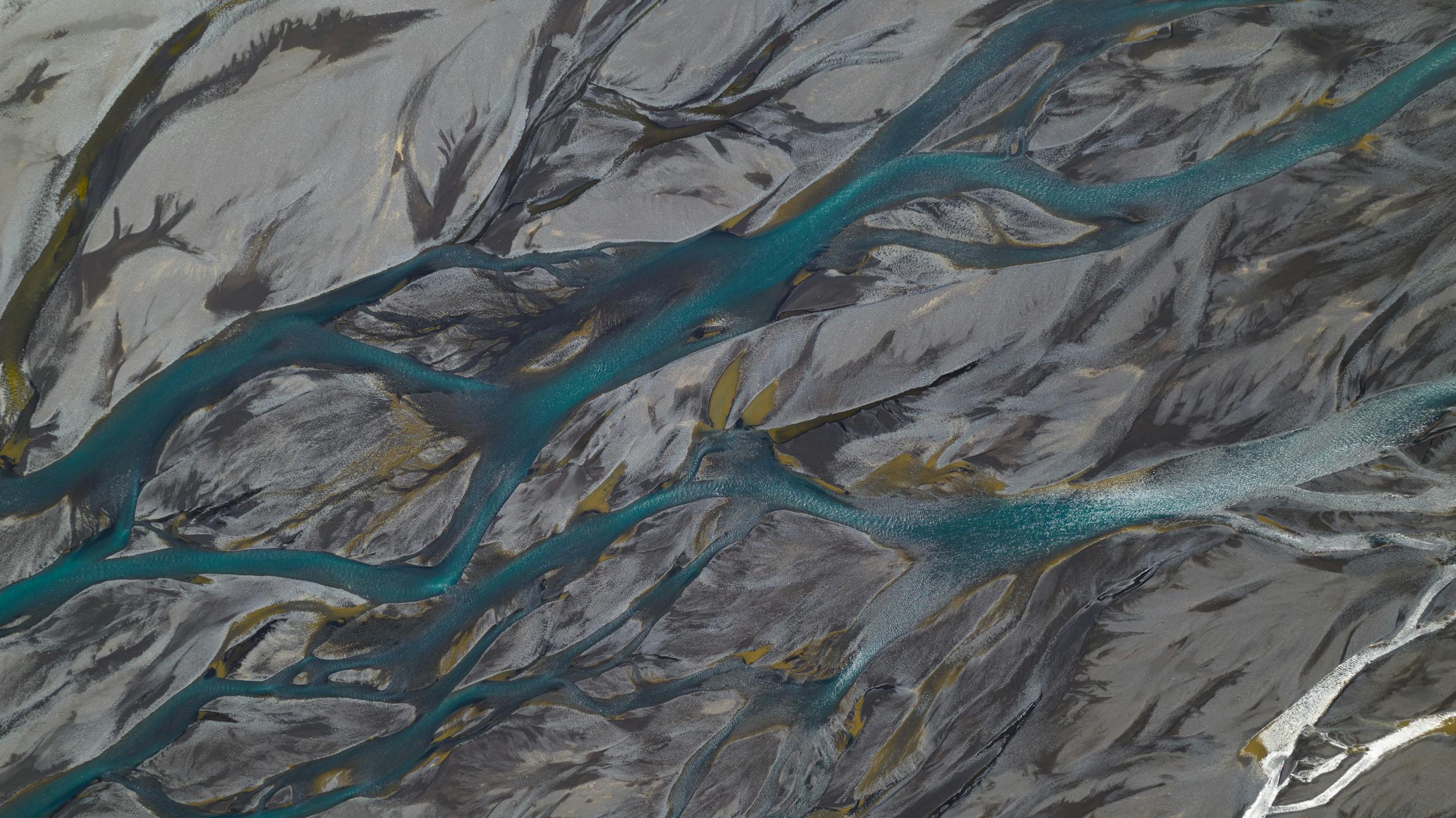 Trencher for Drainage Aerial view of river branches over sandbanks creating natural abstract patterns in earthy tones.