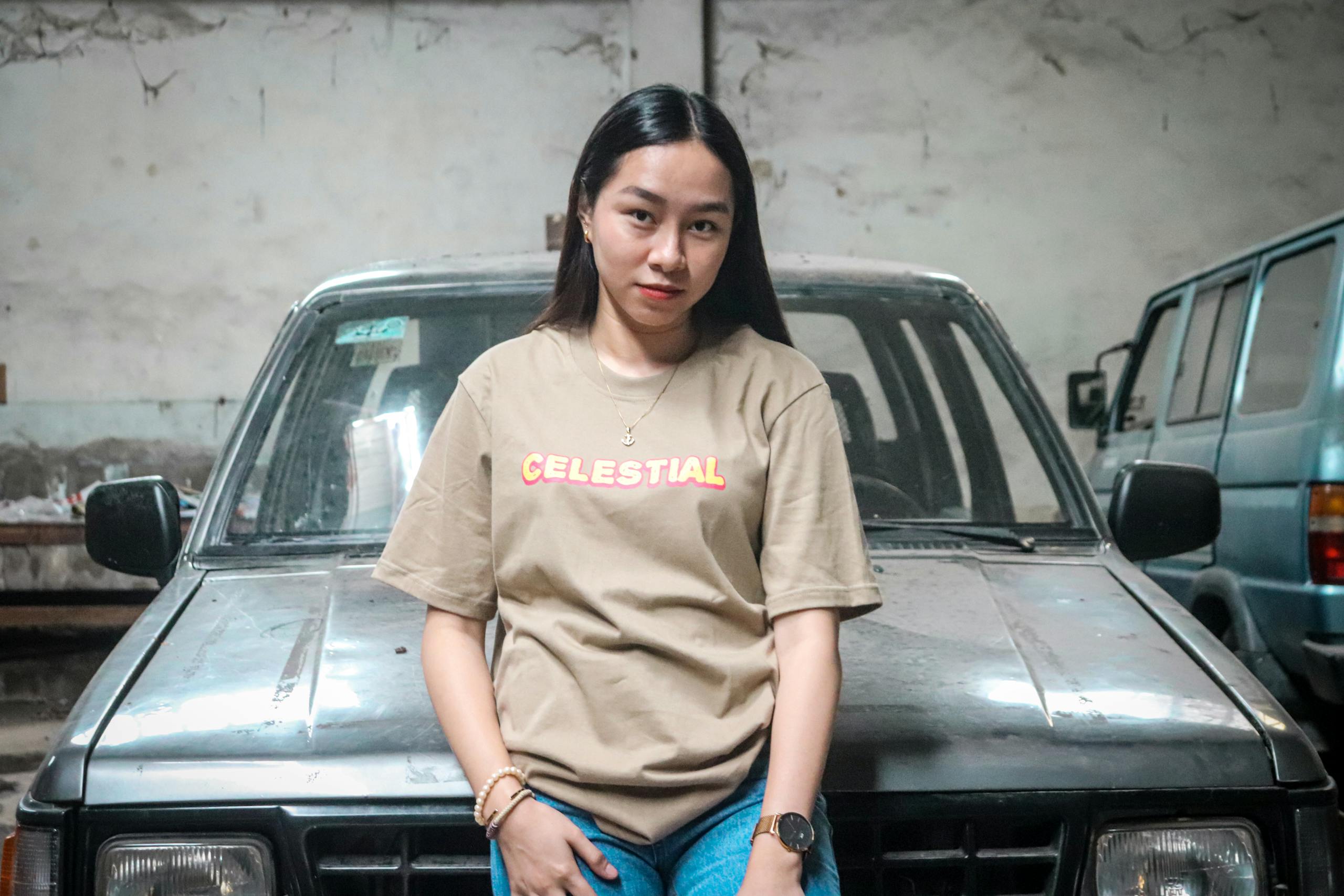 Asian Pinay Asian Pinay in casual attire posing confidently in an urban environment against a car.