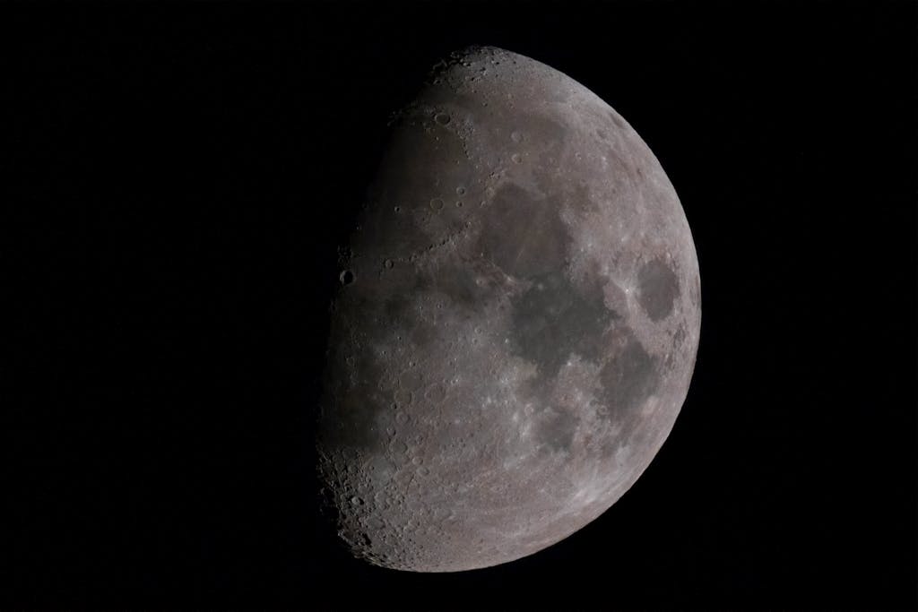 Lufanest Captivating detailed photograph of the moon in its first quarter phase against a dark sky.