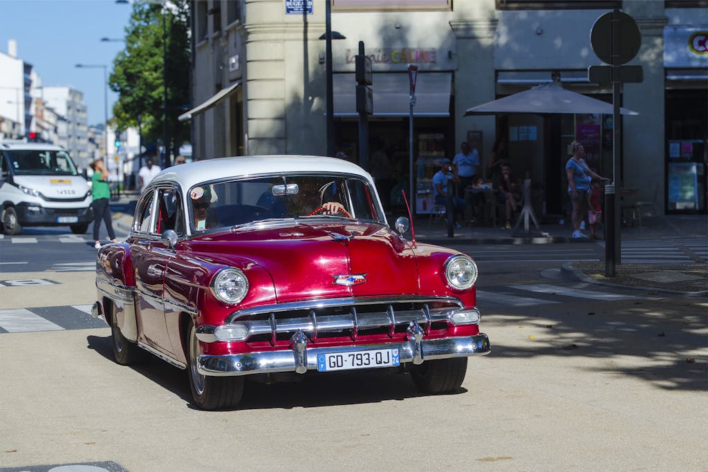 Bolly4u Me Classic red vintage car on a sunny street in Périgueux, France, capturing a nostalgic moment.