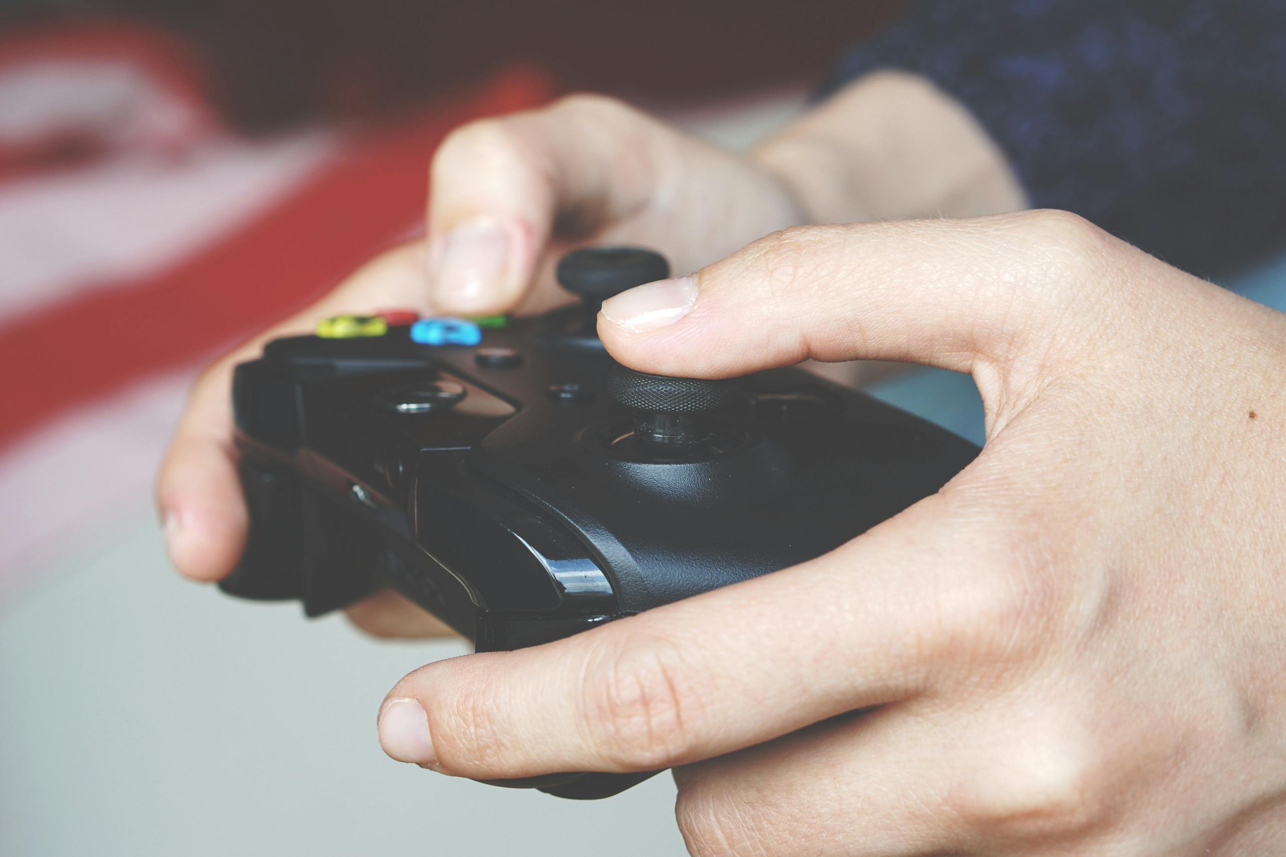 Xbocmy Close-up image of hands gripping an Xbox game controller depicting immersive gaming technology.