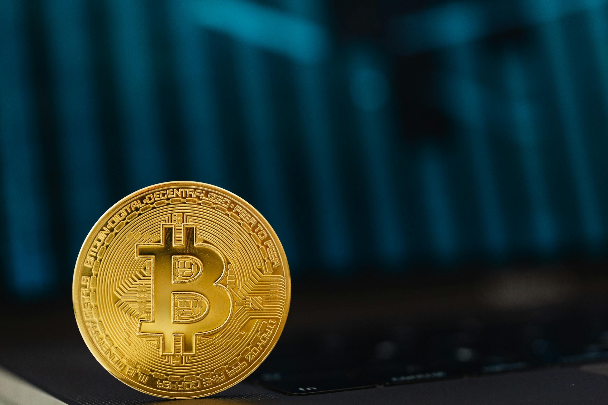 Kellogg Innovation Network Close-up of a golden Bitcoin coin on a computer keyboard symbolizing digital currency and blockchain technology.