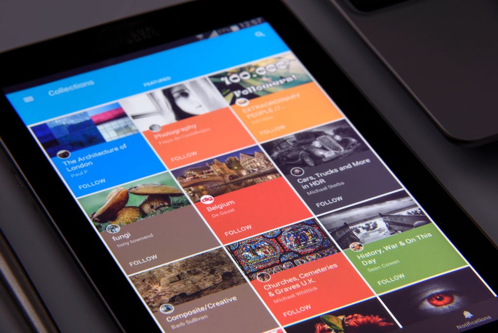 Newstoday Close-up of a tablet displaying diverse content collections in a grid format.