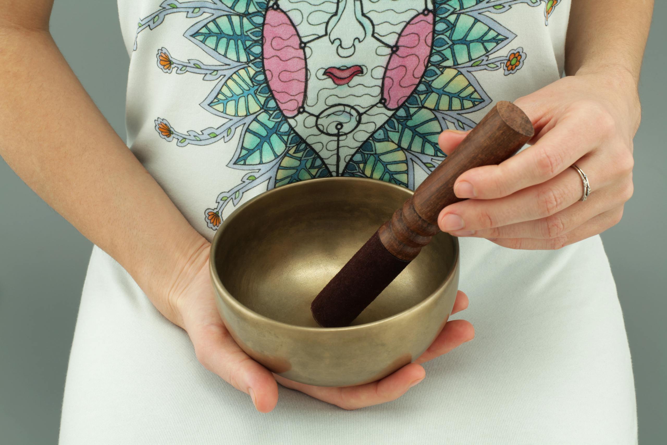 Kinervus Close-up of hands holding a Tibetan singing bowl for meditation and relaxation.
