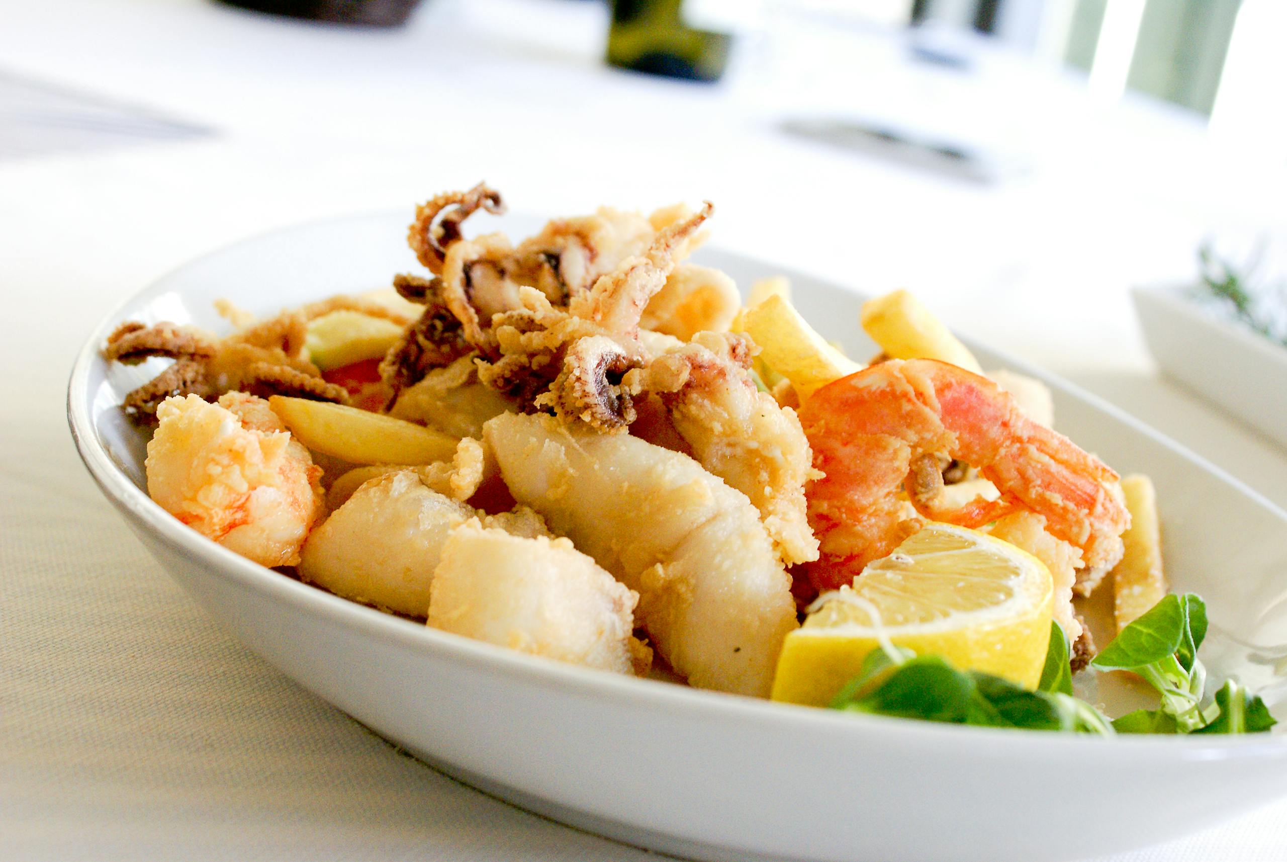 Calamariere Delicious Italian Fritto Misto featuring shrimp, squid, and lemon slices. Perfect for seafood lovers.