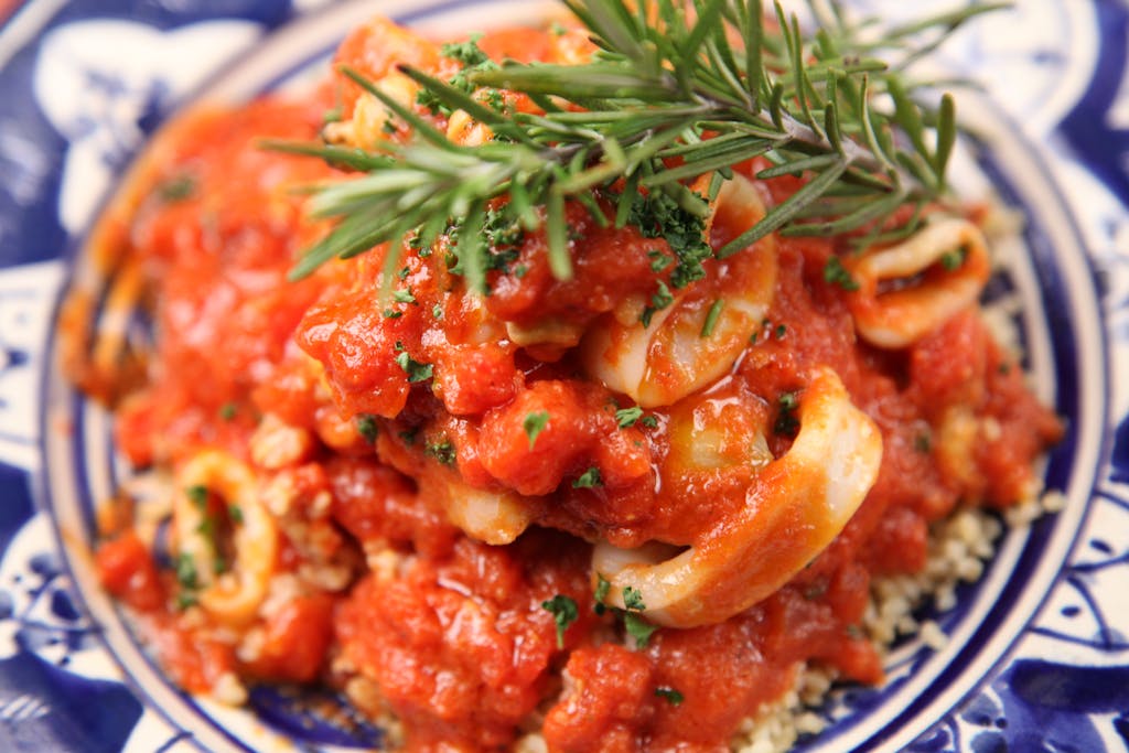 Calamariere Delicious Italian-style seafood dish topped with fresh herbs and savory tomato sauce.