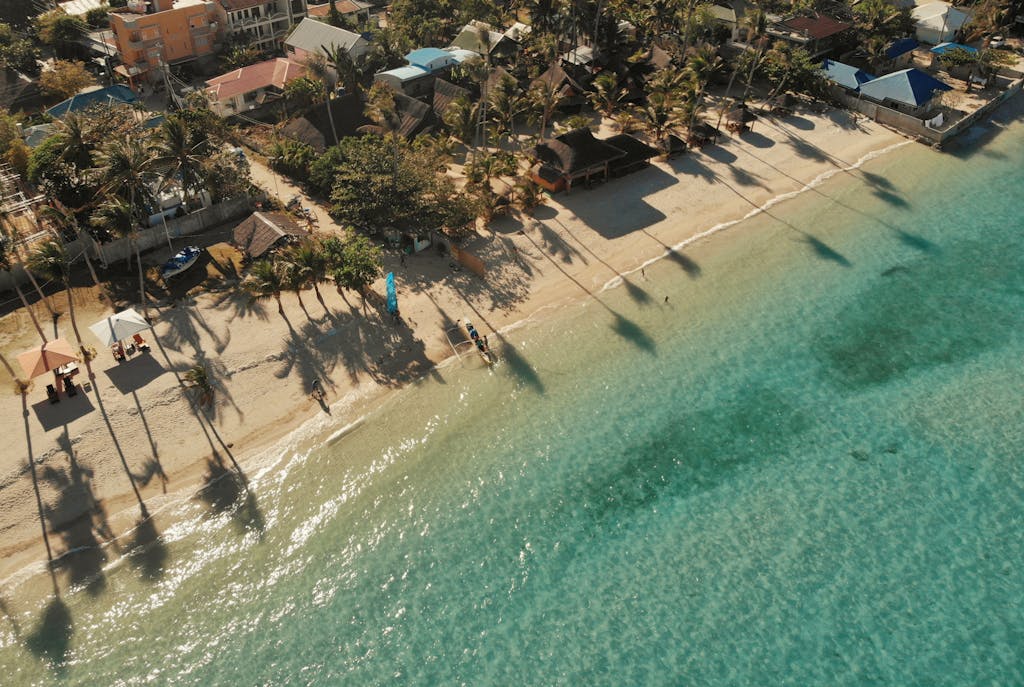 Cevurı Discover the tranquil beachfront of Santa Fe, Philippines, captured from above, highlighting palm-lined shores and clear waters.