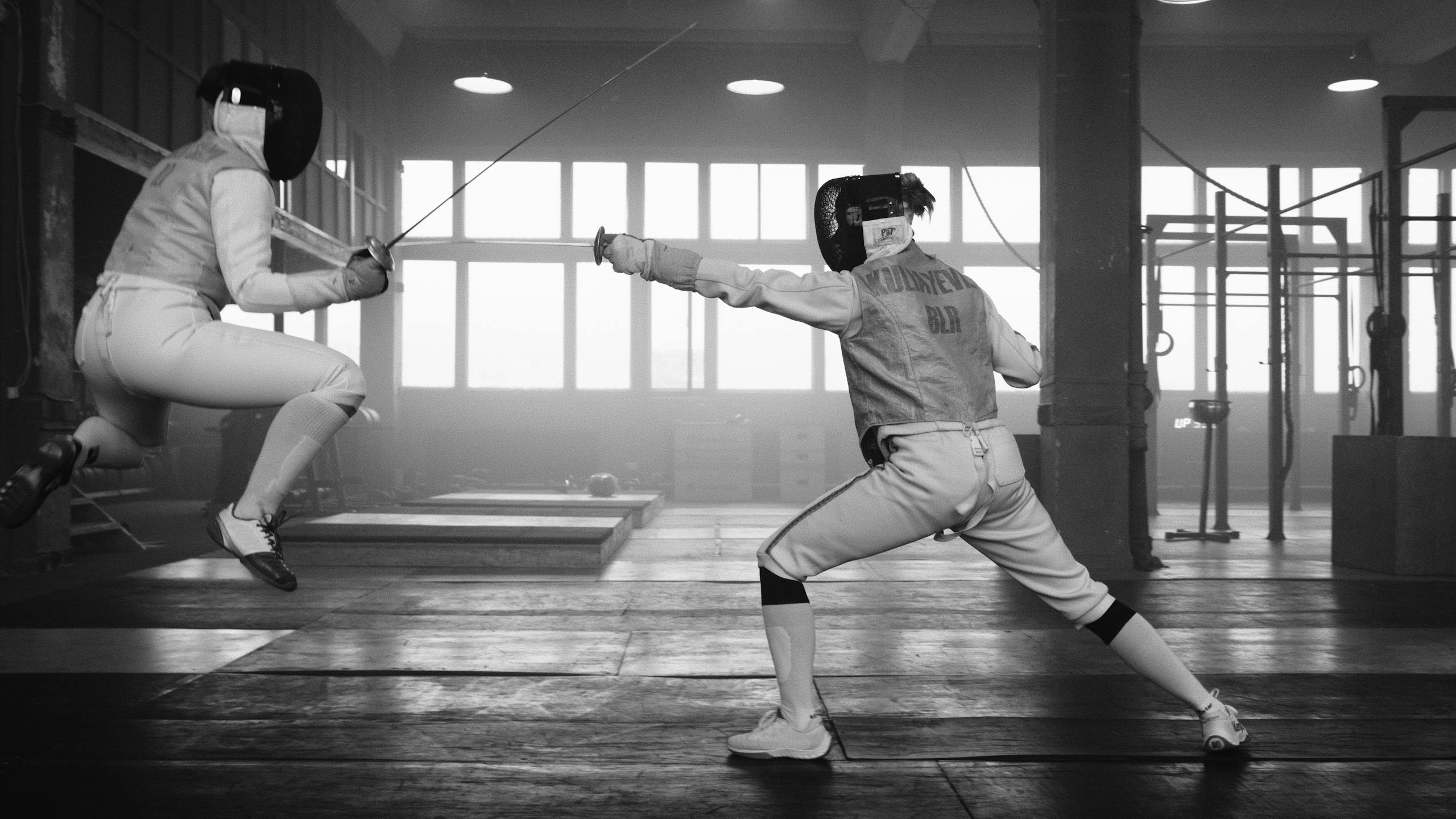 Brandi Loge Intense fencing duel captured indoors with athletes in action.