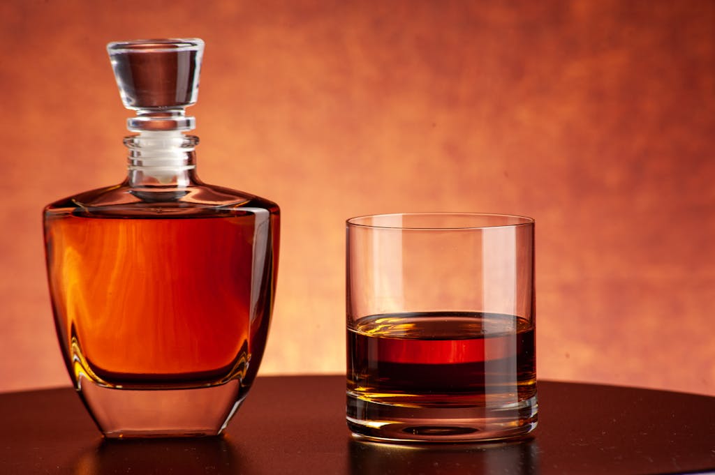 Brandi Loge Luxurious whiskey decanter and glass set against a warm, inviting backdrop. Perfect for bars and homes.
