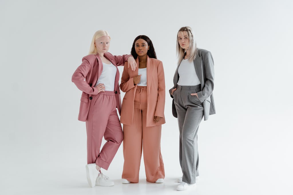 Blazertje Three diverse women in stylish suits standing confidently in a studio.