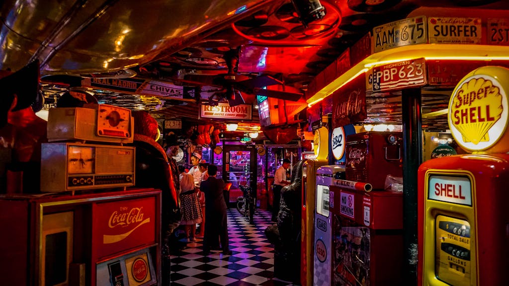 Onnilaina Vintage arcade bar with retro signs, people, and neon lights.