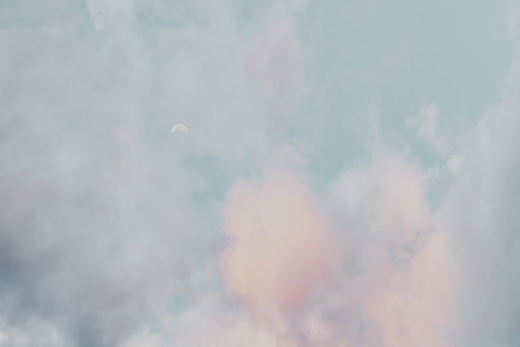 Chatpic A serene scene of pastel clouds and a subtle moon in a calming sky, perfect for a peaceful backdrop.
