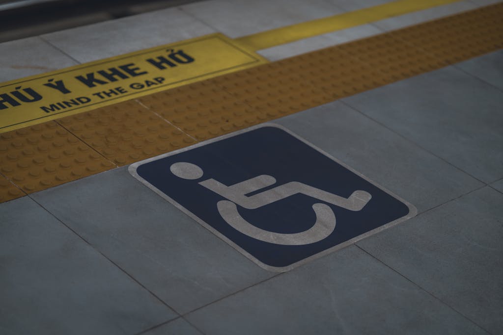JuntosSeguros Close-up of handicap symbol and 'Mind the Gap' warning on a station platform.