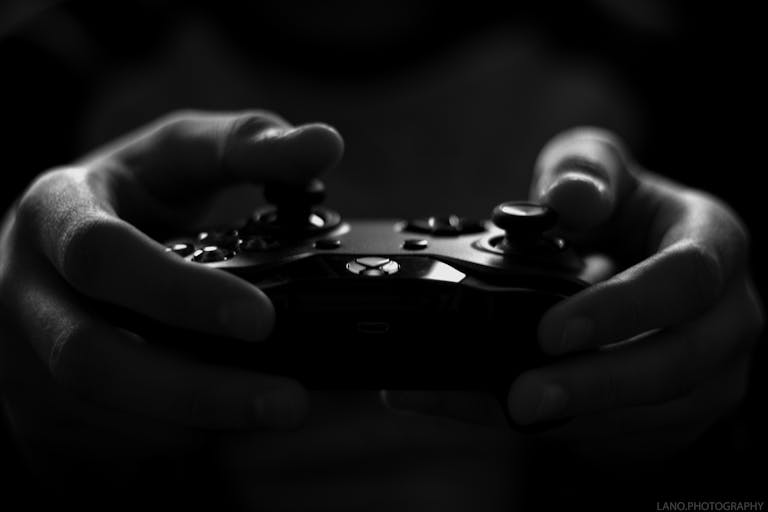 hj54kyf Close-up of hands holding a game controller in a monochrome setting, capturing the essence of gaming.