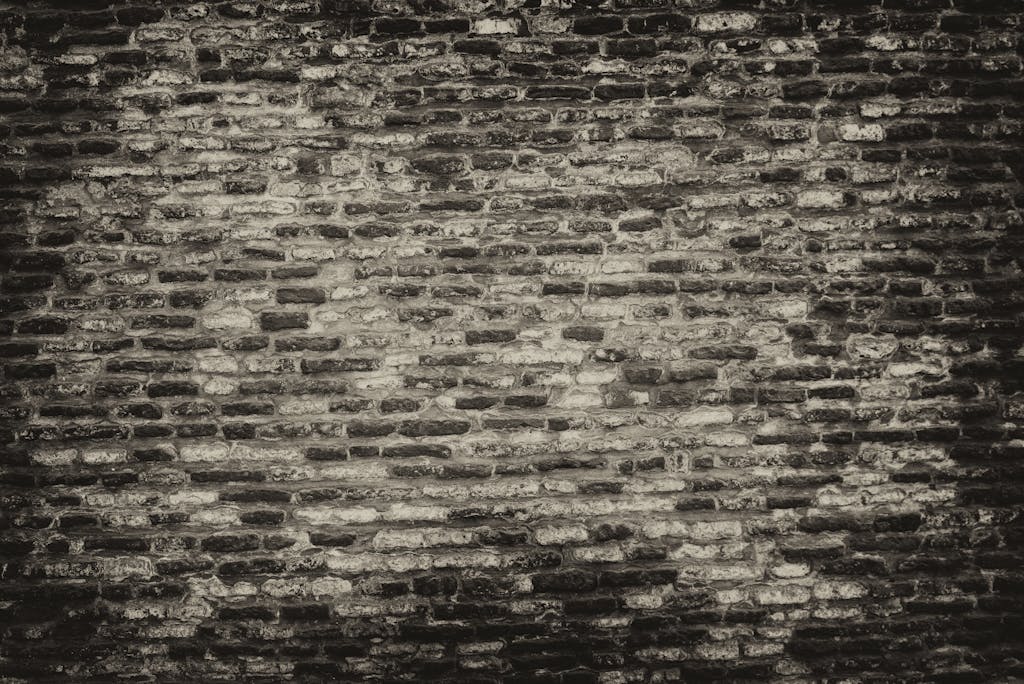 Cray0lav0mit  Grayscale textured brick wall background with rough surface.