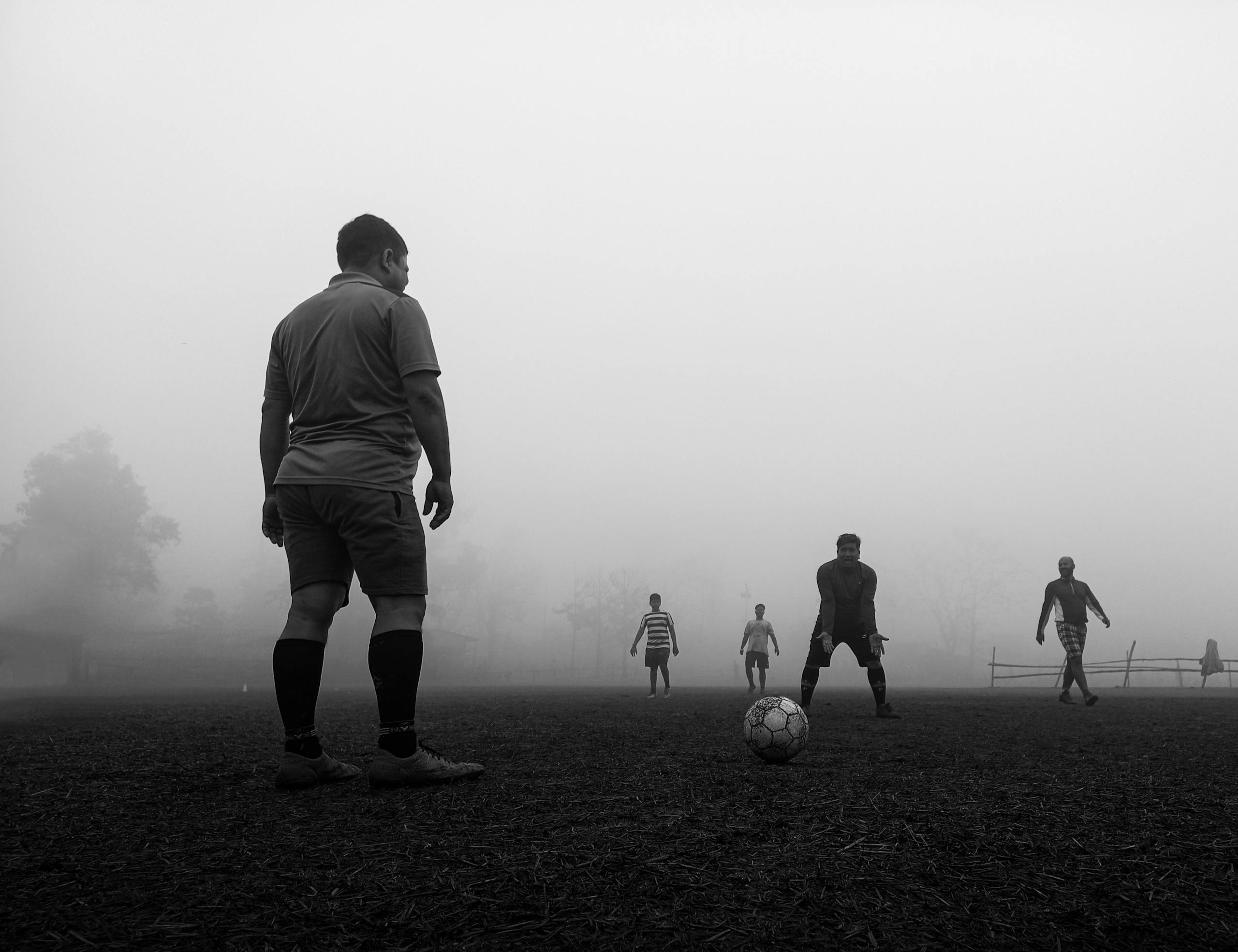 New York Jets vs Bengals Match Player Stats Men play soccer in a foggy field in Kolkata, capturing a moody sports moment.