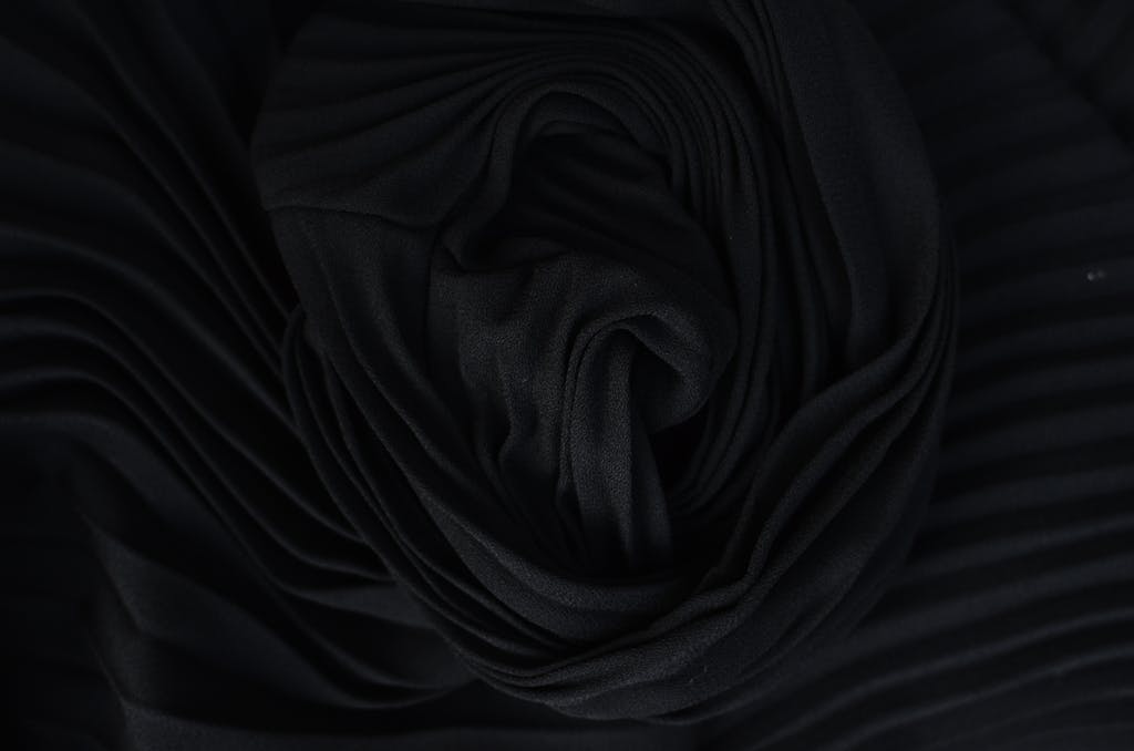 N123Safe67 Top view of abstract background representing wavy creased black silk fabric in twilight