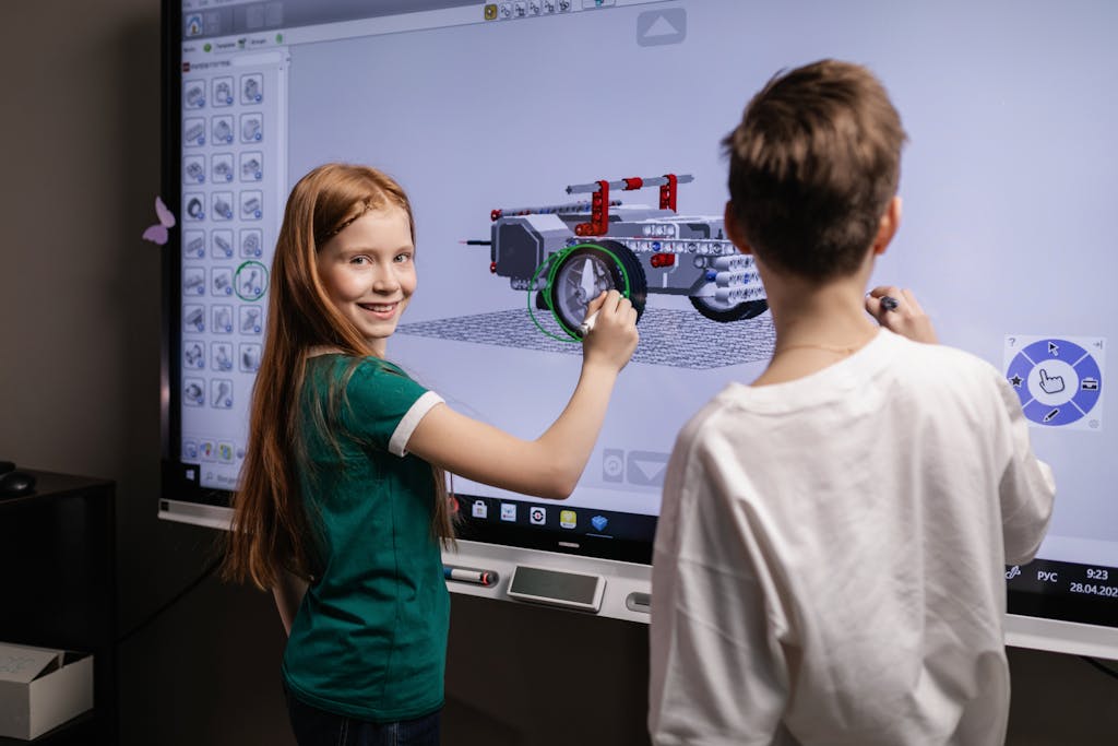 Edivawer Two children interacting with a digital screen in a classroom setting, learning through technology.