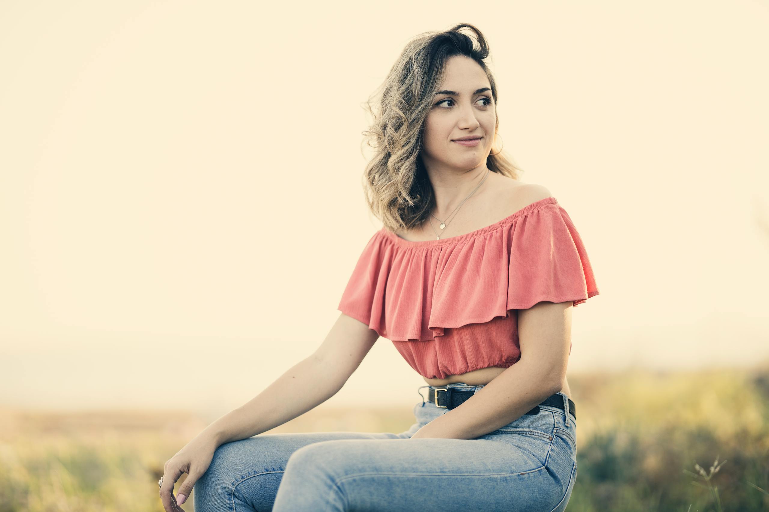 veb vatsap com Portrait of a smiling woman in a pink top enjoying a sunny day outdoors.